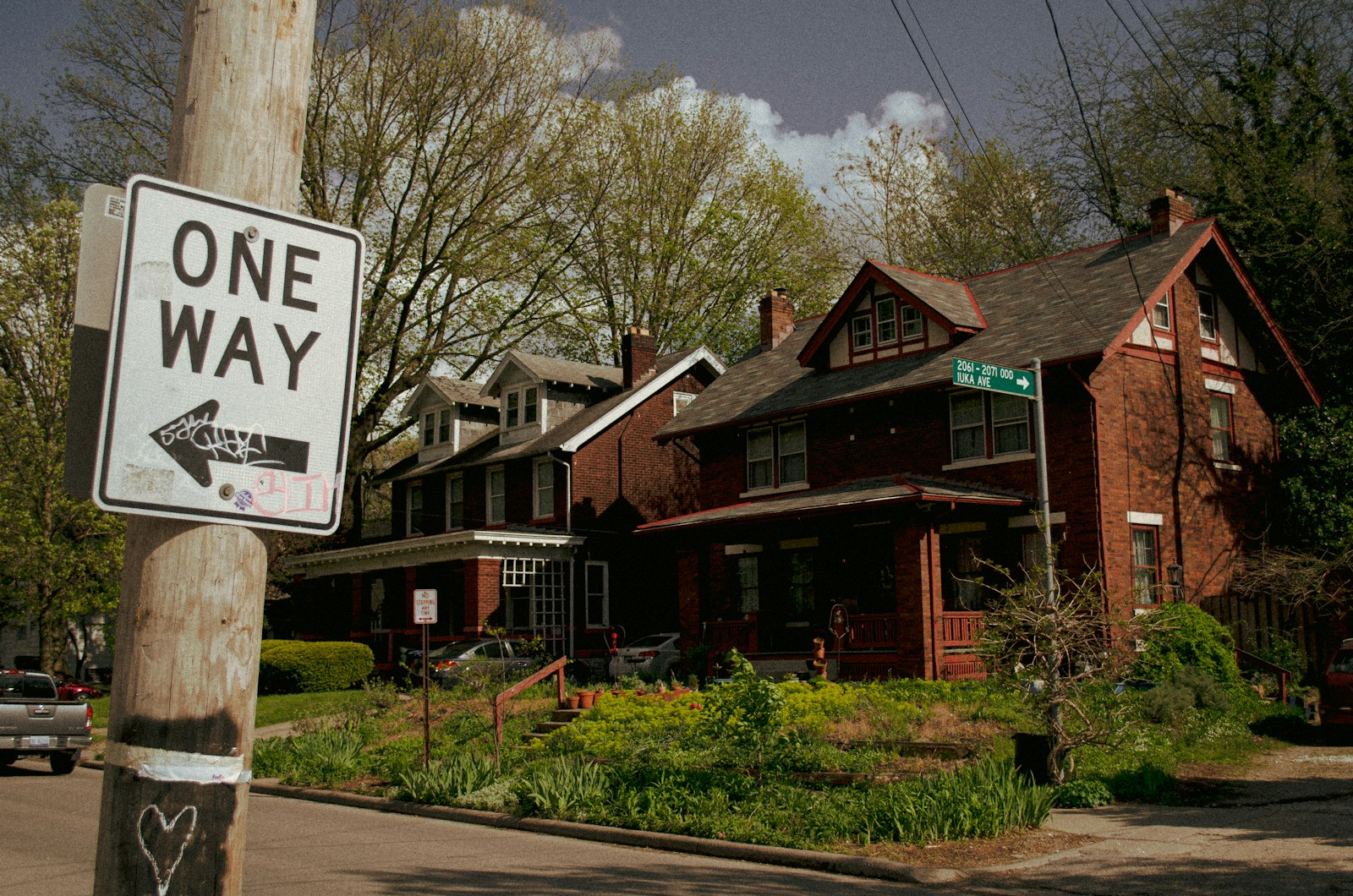 Street sign near brown house during daytime